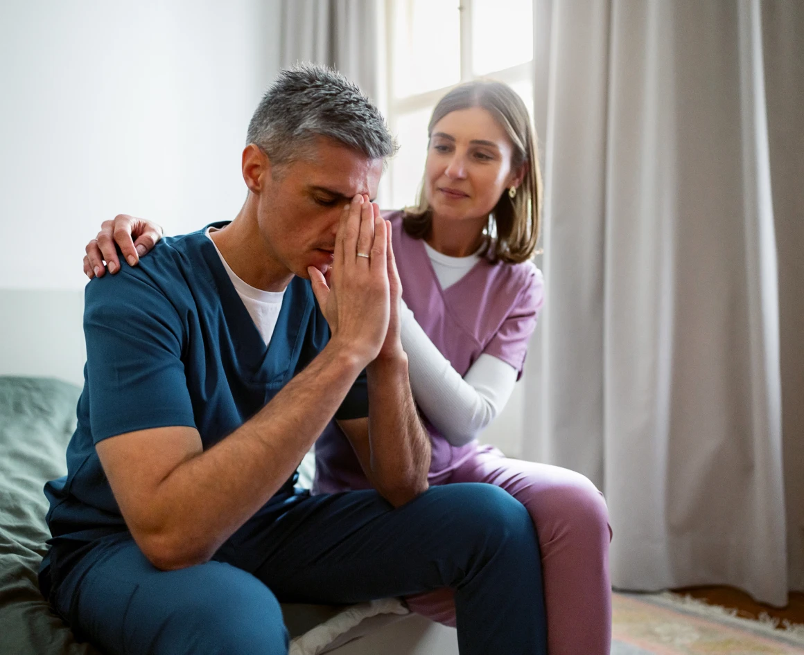 Nurse consoling a stressed colleague